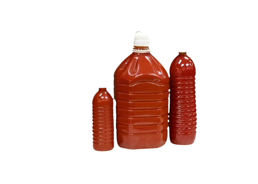 Three plastic bottles of ketchup in varying sizes, arranged against a black background. The largest bottle has a white cap, while the others are smaller and have red caps.