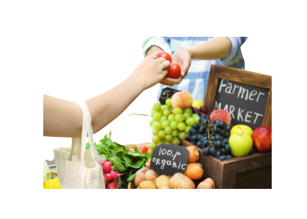 A person hands an apple to another individual at a farmer's market, surrounded by various fresh fruits and vegetables. The scene conveys a vibrant and community-focused atmosphere.